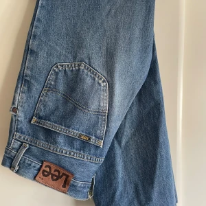 Lee blåjeans cargopants stl 32/32 - Snygga blå cargopants från Lee i klassisk jeanskvalitet. Byxorna har stora fickor på sidorna och Lee-lapp i brunt läder bak. Tillverkade i slitstarkt bomullsjeans med raka ben och coola detaljer. Perfekta för en avslappnad streetstil. Begagnade men sparsamt använda.