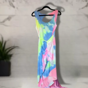 Färgglad asymmetrisk klänning L - Säljer en supercool kortklänning i storlek L med tie-dye mönster i blått, rosa, gult och vitt. Klänningen har ärmlös design, öppen rygg och en snygg asymmetrisk nederkant. Perfekt för dig som vill sticka ut med färg och unik stil i sommar!
