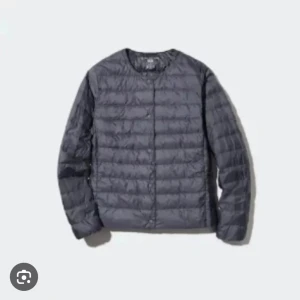 Mörkgrå quiltad dunjacka - Snygg mörkgrå dunjacka med quiltad design och rund halsringning. Jackan har knäppning framtill och är lätt vadderad. Långärmad och i en stilren, enkel modell som funkar till det mesta.