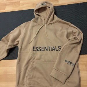 Beige Essentials Fear of God hoodie - Essentials Hoodie – XL (Brun/Beige) Säljer en snygg och bekväm Essentials hoodie i storlek XL. Färgen är en stilren brun/beige ton som passar till det mesta. Hoodien är i klassisk oversized passform med hög komfort, perfekt både till vardags och streetwear.  ✔️ Storlek: XL ✔️ Färg: Brun/Beige ✔️ Äkta Essentials ✔️ Skick: Mycket bra skick 
