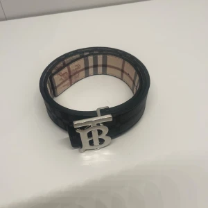Burberry bälte - Ett reverseble burberry bälte så man kan byta sida på bältet så man har både svart och beige bälte med silvrig logga och den är helt ny och den är i 105 cm. Pris kan diskuteras och skriv om du har några frågor. 