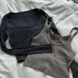 Svart ribbad långärmad topp och grått linne  - Säljer dessa två toppar i ett set för bara 100kr. Båda topparna är från Brandy Melville . En svart ribbad långärmad topp med rund ringning och vågig kant nertill.  En grå ribbad topp med smala axelband och en fin passform. Båda topparna är i onesize, ( xs/s ) 