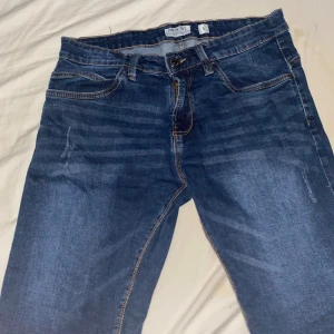 Blå jeans med kontrastsömmar - Snygga blå jeans från Only med klassisk femficksdesign och kontrastsömmar. Jeansen har normal midja och raka ben, samt slitningar framtill för en cool look. Perfekta för dig som gillar en tidlös stil med lite edge. Pris kan diskuteras 