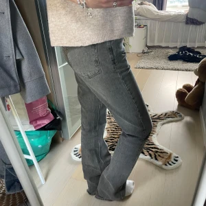 Grå raka jeans med bootcut - Säljer ett par grå jeans med rak passform och lätt bootcut. Jeansen har klassisk femficksdesign och är tillverkade i ett mjukt denimtyg. Perfekta för dig som gillar en avslappnad men ändå stilren look.