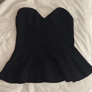 Svart stickad tubtopp med volang - Supersnygg svart stickad tubtopp med volang nertill. 💗