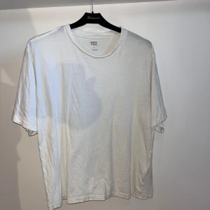 Vit basic t-shirt från 157, stl S - Enkel vit t-shirt från 157 i storlek S. Tillverkad i 100% bomull med klassisk rund hals och korta ärmar. .