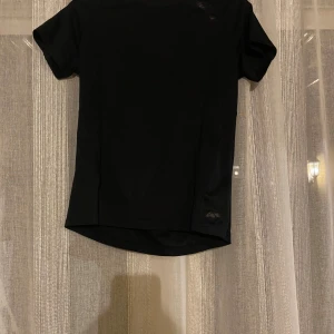 Svart sportig t-shirt - En svart, stilren t-shirt ingen aning om vilket märke de är då de har försvunnit kan inte se storleken heller men skulle säga XS/S