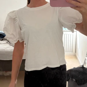 Vit T-shirt med volang - Säljer denna vita T-shirt med volang/puff ärm. Super fin! Storlek S