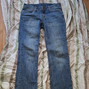 Blå jeans  - Säljer ett par klassiska blå jeans från brandy melville i storlek S. Jeansen har raka ben, normal passform och är tillverkade i bomull med lite elastan för extra stretch. Snygga detaljer med slitna kanter nertill och diskret tvättad look. Är lite sliten n längst ner