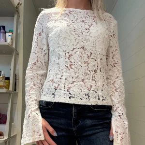 Vit spetsblus  - Vit spetsblus med vida ärmar och slits. Har en dragkedja på sidan. Är storlek 42 och sitter en aning löst på mig som bär S, men beror på hur man vill att den ska sitta. 