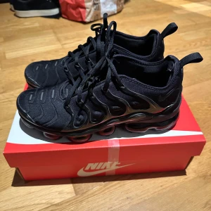 Nike Air Vapormax  - Nike Air Vapormax sneakers i helsvart färg med snygga detaljer och synlig luftdämpad sula. Ovandelen är i syntetmaterial med coola vågformade paneler och snörning. Perfekt för dig som gillar sportig och modern stil. kan gå ner i priset vid snabbt köp.