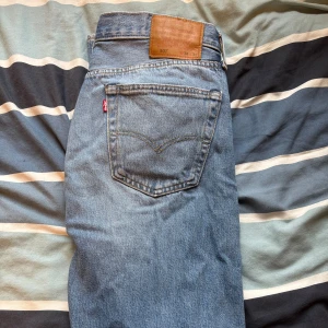 Levi's 501 ljusblå jeans W34 L32 - Säljer ett par klassiska Levi's 501 Premium jeans i ljusblå tvätt. Modellen har rak passform. Jeansen är tillverkade i slitstarkt bomullsdenim och har den ikoniska läderpatchen bak. 