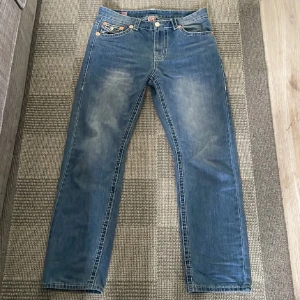 True Religion blå jeans med kontrastsömmar - Feta jeans från true religion. Använda men inga skador som hål eller spräckta sömmar✅. Storlek w34 ✅. Lite lösare i storlek men skulle inte säga baggy. Öppen för prisförslag!