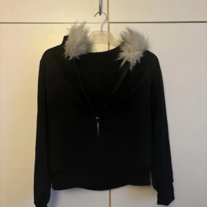 Svart hoodie med päls - Fin hoodie med dragkedja och fickor samt med en skön pälsig luva. Köpt från shein och helt oanvänd. Köpt för 300 kr och säljer för 180 kr. Den är i storlek L