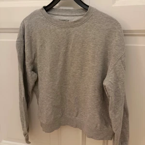Grå sweatshirt - En enkel och stilren grå sweatshirt i ekologisk bomull. Snyggt basic-plagg som är lätt att matcha med allt. Endast använd några fåtal gånger!
