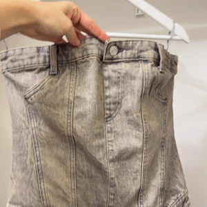 Trendig denim tubtop från ZARA  - Den perfekta toppen för dig som vill sticka ut med stil! Den här denim-inspirerade tubtoppen från ZARA är både edgy och feminin – perfekt att styla med en skjorta, kavaj eller sommarens favoritkjol.  👖 Mjukt och stretchigt material 🖤 Dragkedja bak för perfekt passform 🌸 Storlek S (EU 36) 🔥 Snygg både till vardags och utekvällen