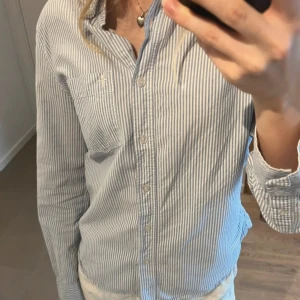 Blå randig skjorta - Blå randig skjorta från Lager 157. Superfint skick! Medium, men ganska liten i storleken, ni ser på första bilden hur den sitter på mig som brukar ha xs.