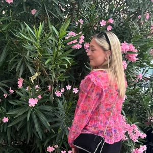 Blommig rosa blus med volang - Säljer en transparent blommig blus i rosa och lila toner med v-ringning, volangdetaljer och puffiga långärmar. 