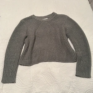 Grön stickad tröja från ONLY - En grön stickad tröja från ONLY i storlek S. Tröjan har ett grovt ribbat mönster, rund hals och långa ärmar. Den är lite croppad i modellen och har en snygg struktur som gör den extra mysig och trendig. I fint skick kanske lite nopprig men inga skador.