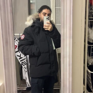 Canada Goose Wyndham - Storlek M. Har använts rent och med försiktighet och är i nyskick. Inga tecken på att jackan är använt och har inga alls defekter. Äkta dunfjädrar i jackan. Kan mötas upp i Stockholm eller skickas med post ifall det behövs. 