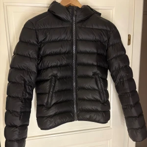 Svart pufferjacka från Colmar - Säljer en svart super skön och varm pufferjacka från Colmar. Den är väldigt sparsamt använd och har inga hål samt inget slitage. Perfekt nu inför vintern