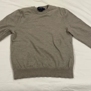 Beige merinoulltröja från Riley - Snygg beige tröja från Riley i mjuk merinoull. Klassisk rund halsringning och långärmad modell, perfekt för lager-på-lager. Enkel och stilren design som funkar till allt. Superbekväm och lätt att matcha med dina favoritjeans eller kjol.