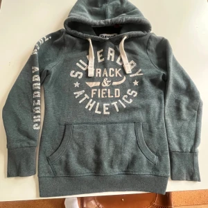 Superdry Hoodie grön  - Säljer denna feta Superdry hoodie i storlek L. Den är väldigt varm och skön, perfekt nu till vintern och hösten. Den är i väldigt fint skick, utan defekter. Hör av er vid minsta fundering!😁