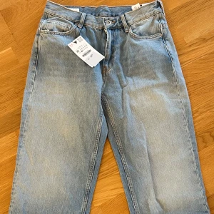  Ny Loose straight jeans från Zara - Snygga ljusblå jeans från Zara i loose straight-modell. Klassisk femficksdesign, normal passform och raka ben. Jeansen har en cool tvättad look och är tillverkade i mjukt bomullsmaterial. Perfekta för en avslappnad och trendig stil.