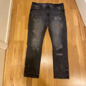 Supply & Demand svarta jeans med dragkedja - Säljer Svarta jeans från Supply & Demand med slitna detaljer Modellen har klassiska fem fickor och en extra dragkedja vid ena fickan. XXL i storlek, hör av vid minsta lilla fråga. Äkta såklart :)