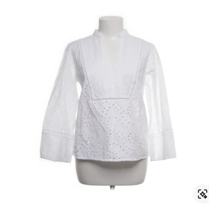 Vit blus Zara - Säljer en vit blus med v-ringning och lång ärm. Blusen har broderade detaljer och spetsmönster med blommiga hålbroderier över hela plagget.  Perfekt för dig som gillar en chill och stilren look.