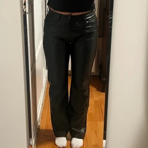 Svarta skinnbyxor från Zara  - Snygga svarta skinnbyxor från Zara i storlek M. Byxorna har rak passform med normal midja och klassiska fickor fram och bak. Materialet är mjukt syntetskinn som ger en cool look. Perfekta för dig som vill ha en trendig vibe.