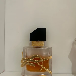 Stilren YSL parfymflaska - Snygg parfym från YSL med modern design och guldiga detaljer. Perfekt för dig som vill ha en lyxig accessoar på hyllan. Ca 1/3 använd 