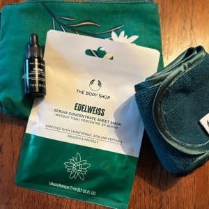 Edelweiss serum sheet mask från The Body Shop - Edelweiss Serum Concentrate Sheet Mask från The Body Shop, med leontopodic acid och peptider för en mjuk och skyddad hud. Medföljer även ett litet serum i svart flaska och en mörkgrön necessär med blommönster samt ett matchande hårband.