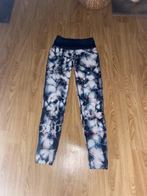 Mönstrade träningstights från SOC - Snygga träningstights från SOC i storlek S med abstrakt mönster i blått, vitt och svarta toner. Hög midja och stretchigt material som sitter tight och bekvämt. Perfekta för gymmet eller löprundan. Har provat dom men aldrig använt