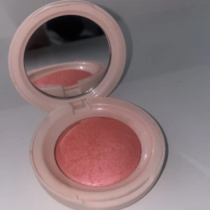 Rare Beauty Powder Blush Cheer - Superfin puderrouge från Rare Beauty i nyansen Cheer. Kommer i en rund, ljusrosa dosa med spegel. 