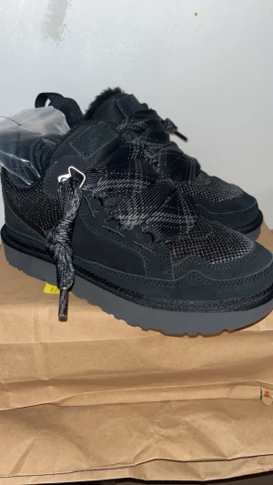 UGG Lowmel sneakers Svart storlek 37 - Helt nya, äkta UGG Lowmel sneakers i svart. Pris kan självklart diskuteras, fraktar vanligtvis samma dag🩷Säljer då jag råkade beställa två, boxen är fortfarande helt oöppnad och de första tre bilderna är alltså på paret jag behåller. Chunky platt sula och rund tå. Ovandel i mesh och mocka med breda snören i randigt mönster, samt extra helsvarta snören så man kan byta (finns inuti påsen). Fodrad insida för extra komfort och värme. Tveka inte att höra av er vid frågor!🫶🏼