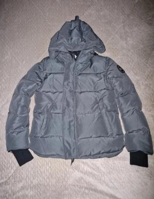 Canada goose macmillan black label - Säljer en grå pufferjacka från Canada Goose Macmillan, modell Fusion M/M. Jackan har huva, ribbade muddar och black label logotyp på ärmen. Materialet är slitstark polyester och jackan har dragkedja framtill. Perfekt för kalla dagar och har en clean, modern look taggar och sånt som jag fick med finns kvar och den är som ny. Pris kan diskuteras och om ni har några frågor så är det och ställa dem 😁😁