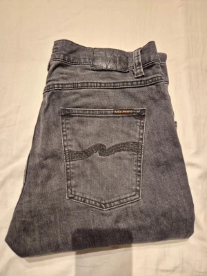 Nudie Jeans Grå - Riktigt snygga gråa Nudie Jeans! Perfekta för en snygg stil och passar till det mesta! Inga skavanker förutom att loggan är lite skrynklig. Skriv om du har frågor!
