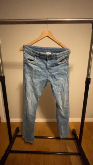 Ljusblå straight jeans mid waist - Säljer ett par ljusblå jeans med raka ben och midja i midwaist-modell. Klassisk femficksdesign och tillverkade i bomull med lite stretch för extra komfort. Perfekta för dig som gillar en enkel och clean look.