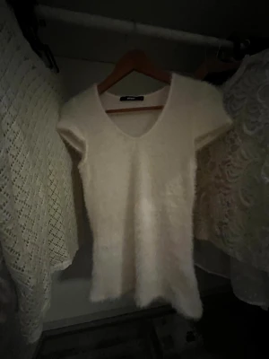 Vit fluffig topp med v-ringning från Bik Bok - Supermysig vit topp från Bik Bok med korta ärmar och v-ringad hals. Super fin passform. Tröjan är endast testad alltså sprillans ny😃👍