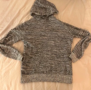 Hoodie - Säljer en gråmelerad stickad hoodie från Youth Carry Clth i storlek M.  Tröja. Är krympt och passar därför Xs-S