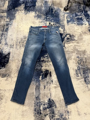 Blåa Replay anbass Jeans - Riktigt feta Replay jeans med en skön blå tvätt. Storlekslappen är borta men de sitter som 32/32. Mycket bra skick. Pris kan diskuteras vid snabbaffär!