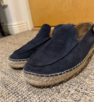Mörkblå mocka loafers från BOSS🤩 - Snygga loafers från BOSS i mörkblå mocka med rund tå och platt sula. Skorna har en klassisk espadrille-look med flätad kant runt sulan och en stilren design utan snörning. Perfekta för dig som gillar en clean och chill stil.