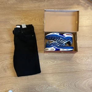 Blå Nike Air Max sneakers - Säljer ett par riktigt snygga Nike Air Max sneakers i blått och vitt. Skorna har en sportig design med tydliga luftbubblor i sulan och coola detaljer längs sidorna. Perfekta för dig som vill sticka ut med färg och stil. Samt Jack and Jones jeans.