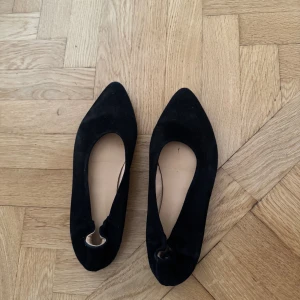 Svarta ballerinaskor med spetsig tå - Snygga svarta ballerinaskor i mocka med spetsig tå och rundad öppning. 