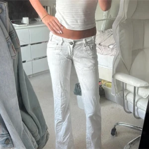 Vita lågmidjade jeans - Säljer ett par vita lågmidjade jeans. Byxorna har snygga detaljer på bakfickorna. Säljer pga dom är för korta. Jeansen säljs inte längre. Midjemått: 35 innerbenslängd: 76 Midjehöjd: 17 🥰