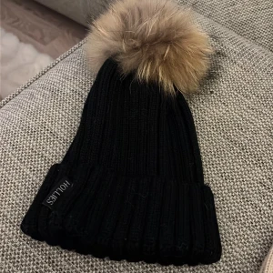 Svart ribbad mössa med pälsboll Hollies - Svart mössa ifrån Hollies, äkta päls. Använd max 3 gånger