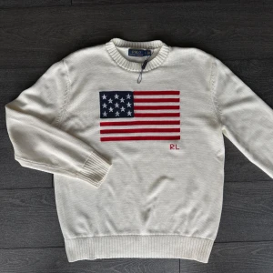 Vit stickad tröja Polo Ralph Lauren - Vit stickad tröja från Polo Ralph Lauren med amerikansk flagga framtill FAST PRIS!!!✅