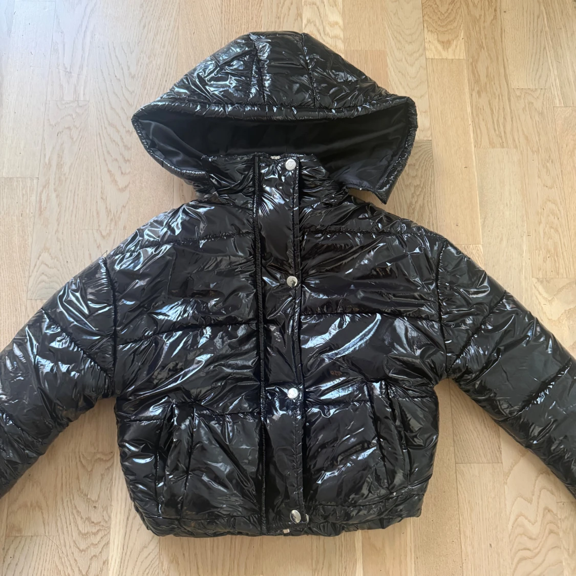 Svart glansig pufferjacka med huva