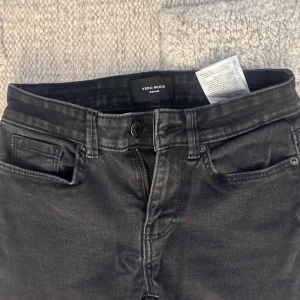 LOWWAIST Svarta bootcut jeans från Vero Moda - Snygga svarta jeans från Vero Moda med klassisk femficksdesign och bootcut-ben. Jeansen har hög midja och är tillverkade i mjukt denim-material med dragkedja och knapp framtill. Perfekta för dig som gillar en tidlös och cool look. Tveka inte på att höra av dig vid frågor eller intresse!